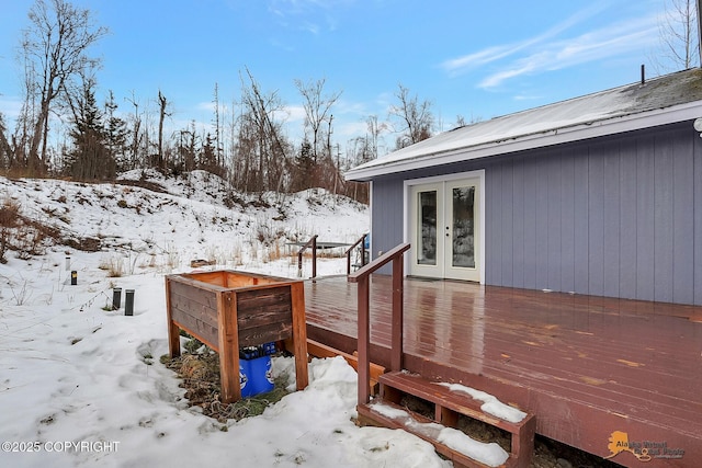 snow covered deck with french doors