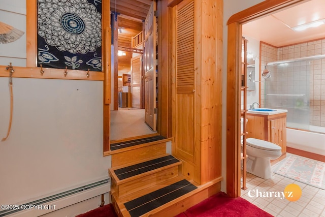 full bathroom with sink, a baseboard radiator, tile patterned floors, toilet, and shower / bath combination with glass door