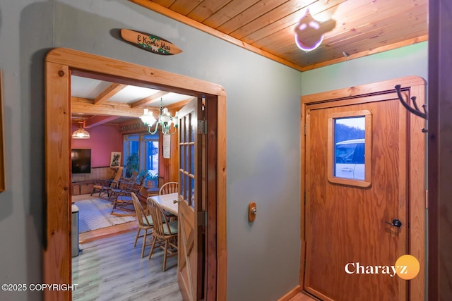 foyer with wood ceiling, crown molding, a notable chandelier, beamed ceiling, and light hardwood / wood-style floors