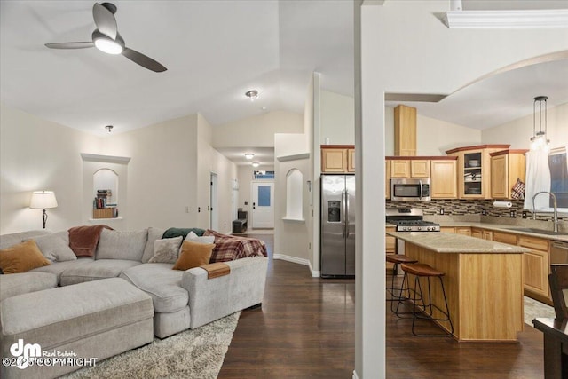 living room featuring dark hardwood / wood-style floors, ceiling fan, lofted ceiling, and sink