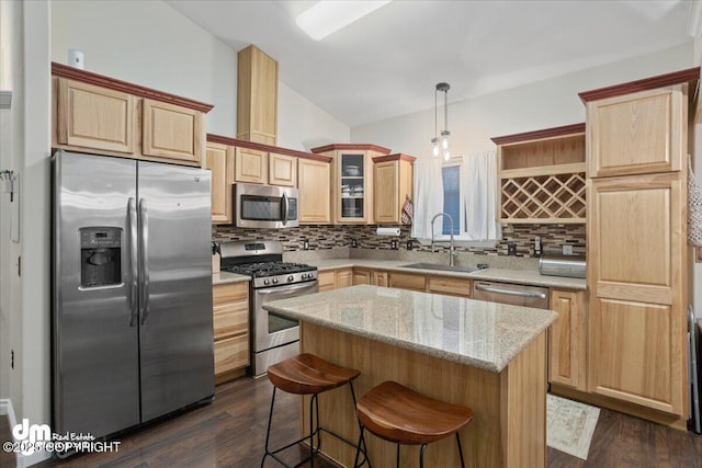 kitchen with sink, a center island, decorative light fixtures, decorative backsplash, and appliances with stainless steel finishes