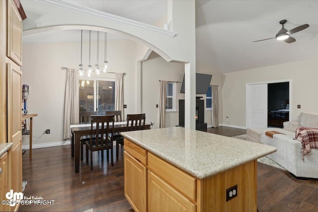 kitchen featuring a center island, hanging light fixtures, dark wood-type flooring, and ceiling fan