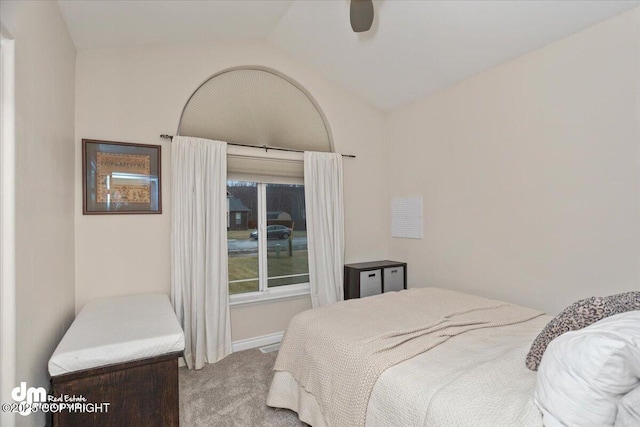 bedroom featuring light colored carpet, vaulted ceiling, and ceiling fan