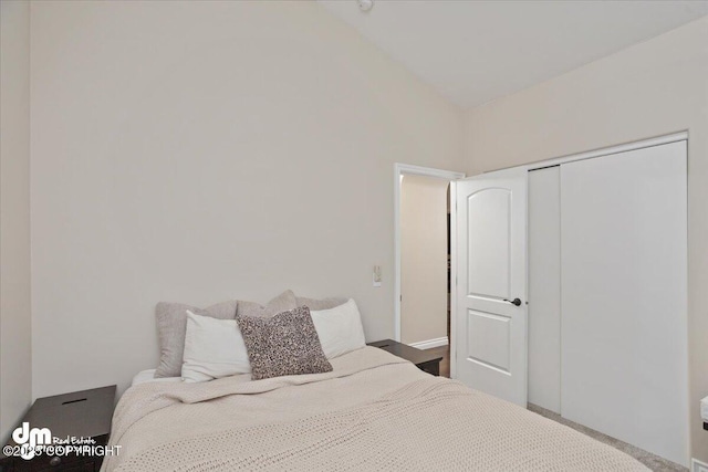 bedroom with vaulted ceiling and a closet