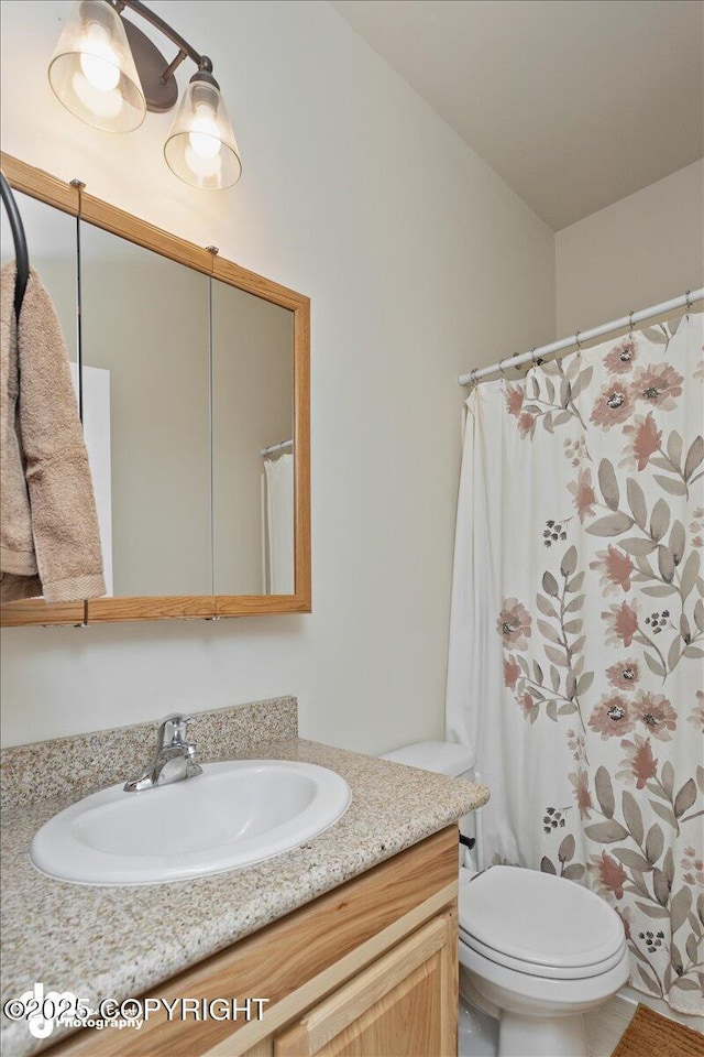 bathroom featuring a shower with curtain, vanity, and toilet