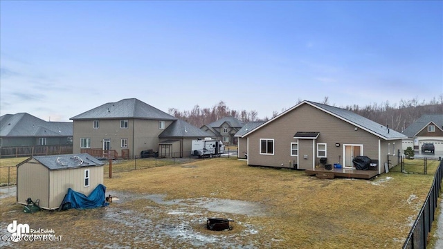 back of house featuring a wooden deck and a storage shed