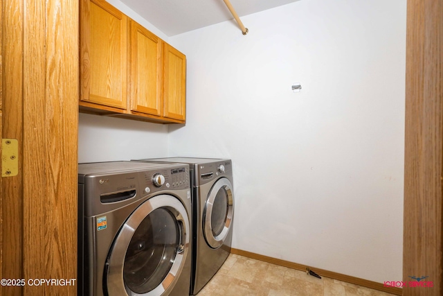 laundry room featuring washing machine and dryer and cabinets