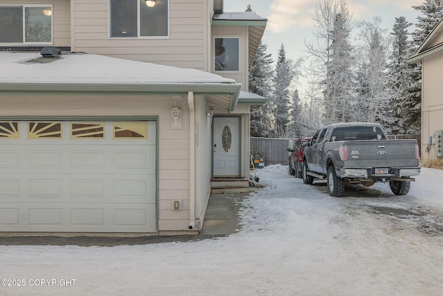 view of snow covered exterior with a garage