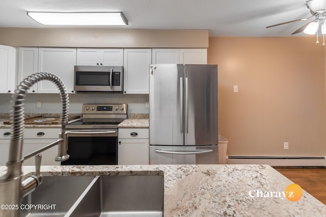 kitchen with decorative backsplash, light stone counters, white cabinetry, and appliances with stainless steel finishes