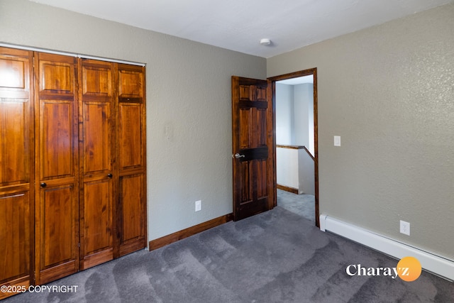 unfurnished bedroom featuring dark carpet and a baseboard radiator