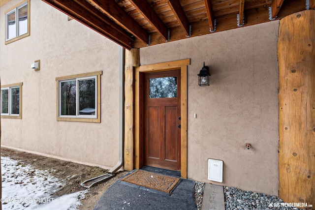 doorway to property featuring stucco siding