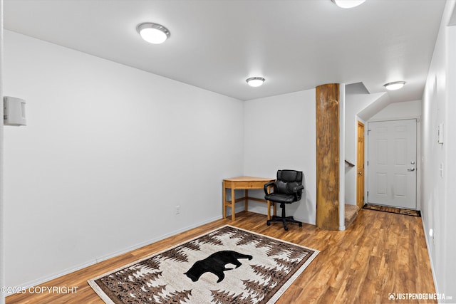 living area with baseboards and wood finished floors