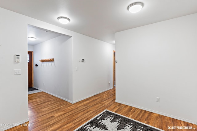 spare room with wood finished floors and baseboards