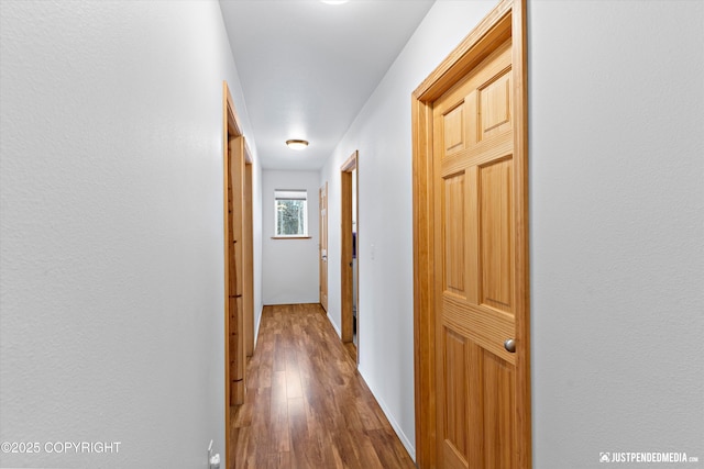 hallway with wood finished floors and baseboards