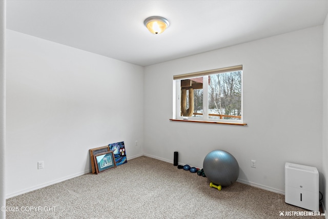 workout area with baseboards and carpet flooring