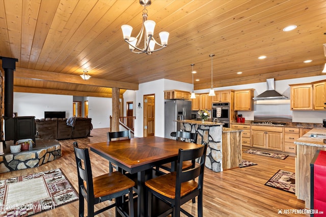 dining area featuring recessed lighting, light wood-style flooring, stairs, and a wood stove