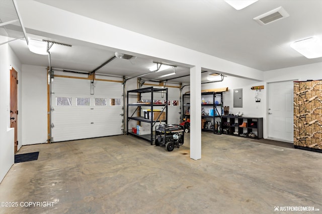 garage with electric panel, a garage door opener, and visible vents