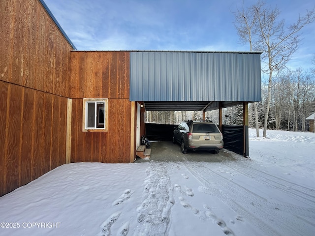 snow covered parking featuring a carport