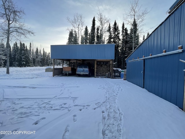 yard covered in snow featuring a carport