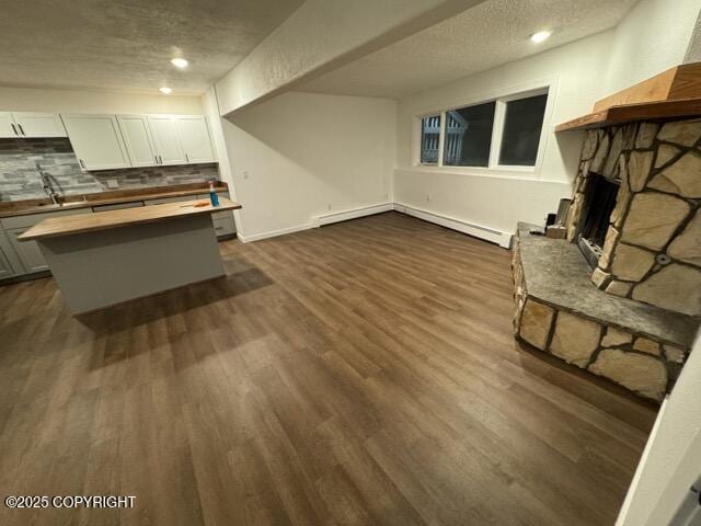 living room featuring a fireplace, a textured ceiling, dark hardwood / wood-style floors, and sink