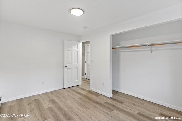 unfurnished bedroom with a closet and light hardwood / wood-style flooring