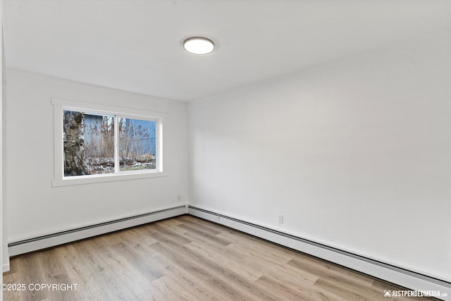 empty room featuring light hardwood / wood-style flooring and a baseboard heating unit