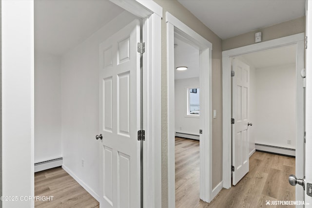 hall with light wood-type flooring and baseboard heating