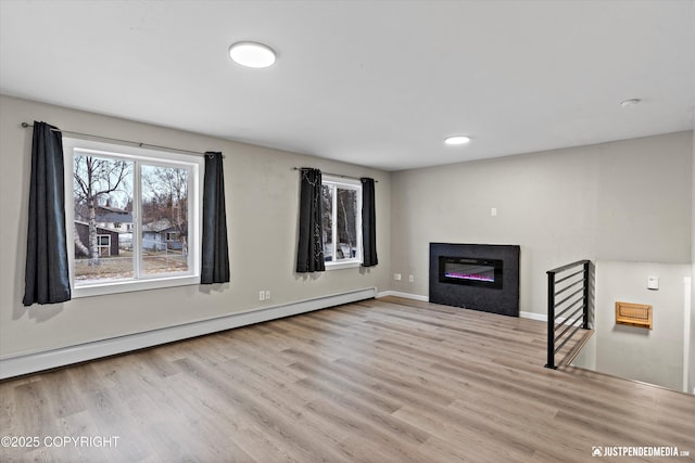 unfurnished living room with a baseboard radiator and light wood-type flooring