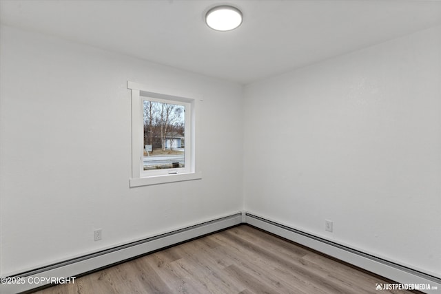 unfurnished room with wood-type flooring and baseboard heating