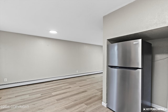 kitchen featuring a baseboard radiator, stainless steel fridge, and light hardwood / wood-style flooring