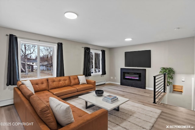 living room with a baseboard radiator and light hardwood / wood-style floors