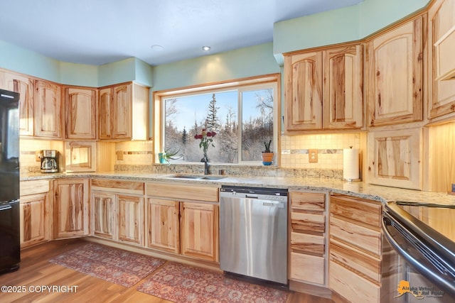 kitchen featuring sink, dishwasher, light stone countertops, and light brown cabinets