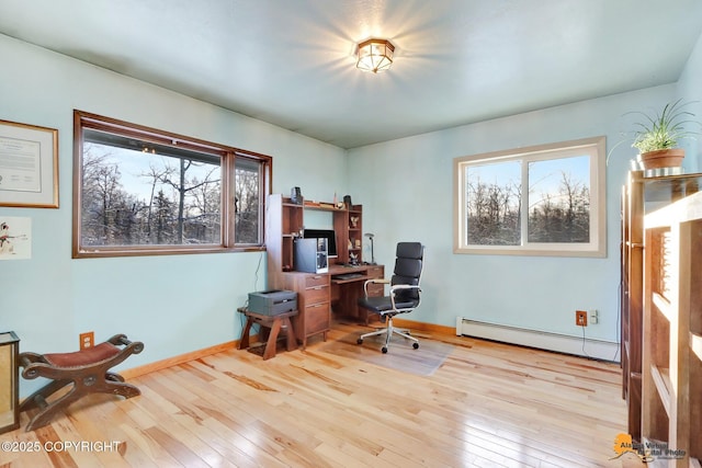 home office featuring a baseboard heating unit and light wood-type flooring