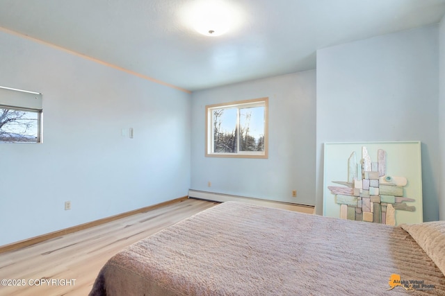 bedroom with a baseboard radiator and light hardwood / wood-style floors