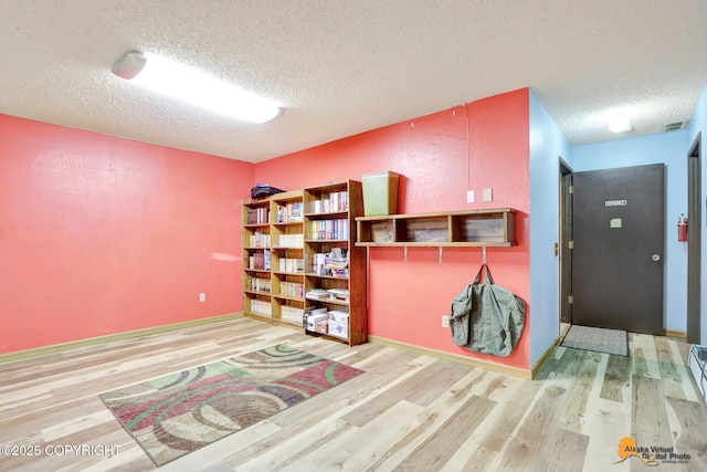 interior space featuring a textured ceiling and light hardwood / wood-style flooring