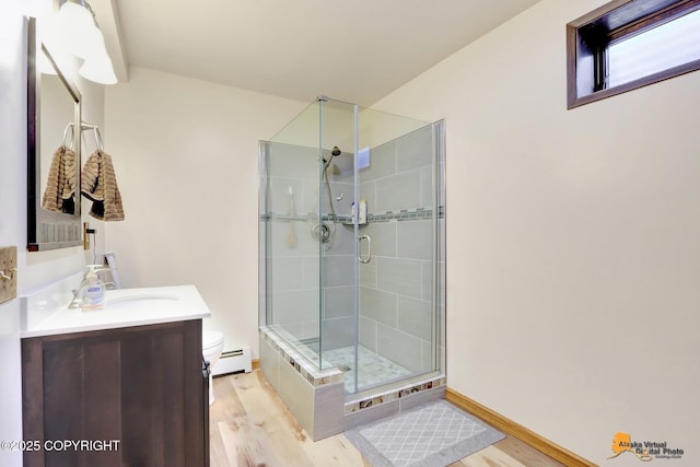 bathroom with toilet, hardwood / wood-style floors, baseboard heating, an enclosed shower, and vanity