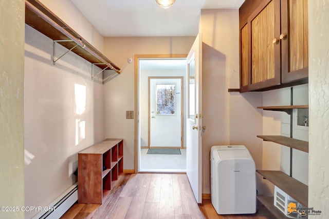 interior space featuring baseboard heating and light hardwood / wood-style floors