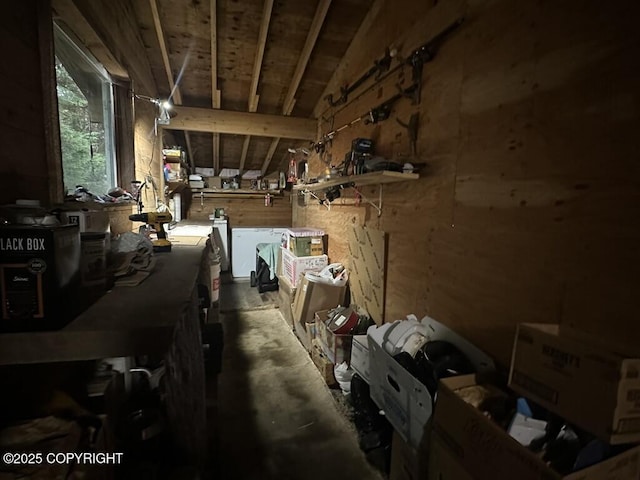 misc room featuring washer and clothes dryer, vaulted ceiling, and a workshop area