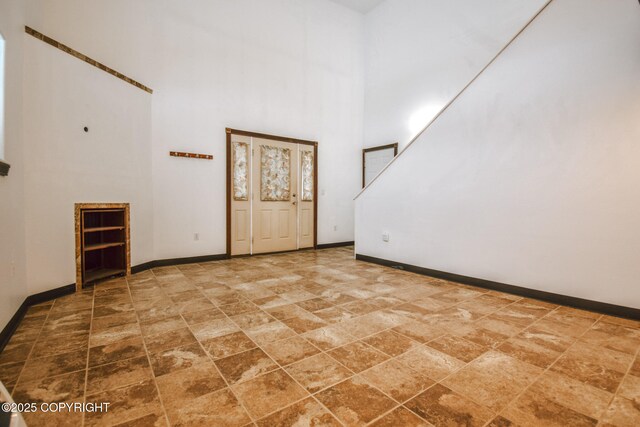 unfurnished room featuring a high ceiling