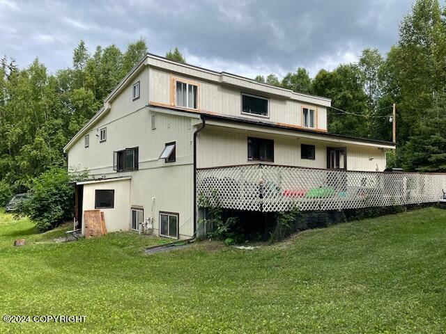 rear view of property with a yard and a wooden deck