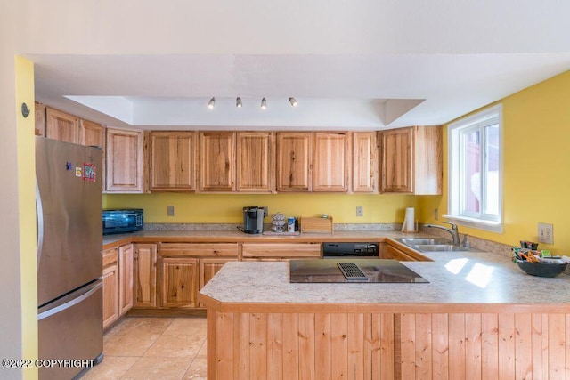 kitchen with kitchen peninsula, a tray ceiling, sink, black appliances, and light tile patterned floors