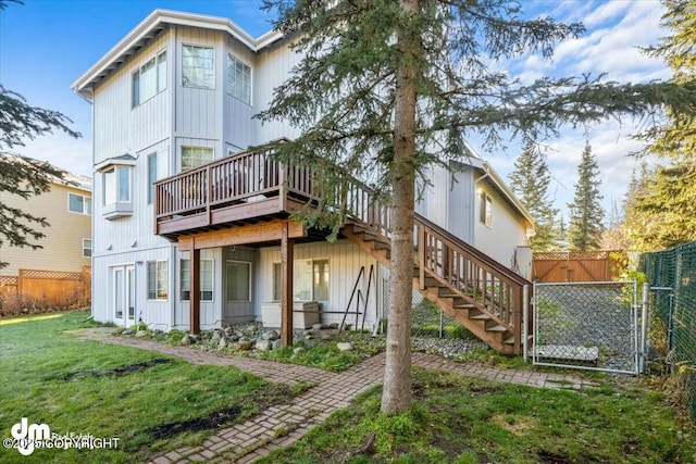 rear view of property featuring a yard and a deck