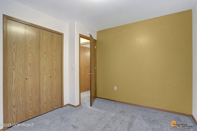 unfurnished bedroom with a closet and light carpet