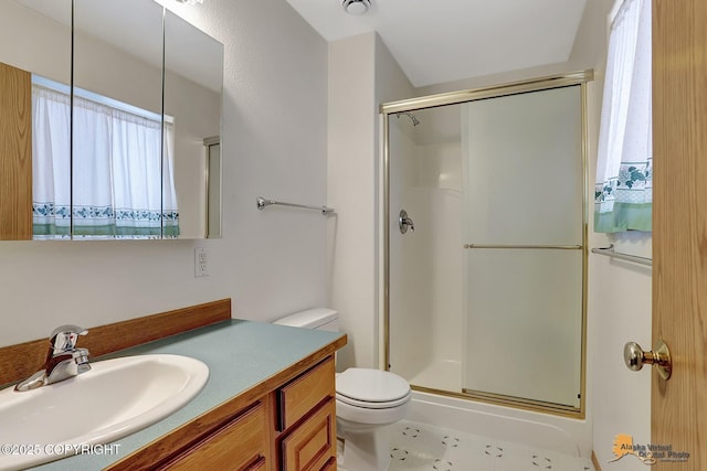 bathroom featuring toilet, an enclosed shower, and vanity