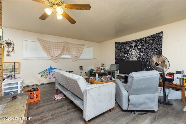 living room featuring ceiling fan and dark wood-type flooring