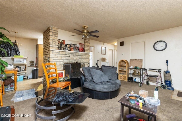 living room featuring carpet, ceiling fan, a fireplace, and a textured ceiling