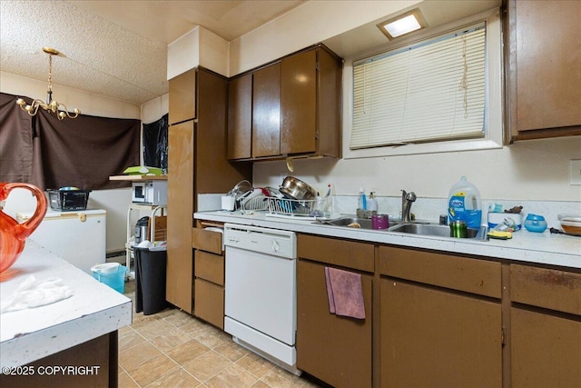 kitchen with a chandelier, a textured ceiling, white appliances, and sink