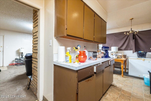 kitchen featuring a notable chandelier, a textured ceiling, and brick wall