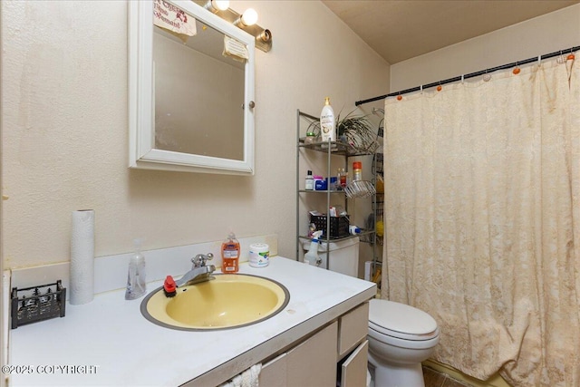 bathroom featuring walk in shower, vanity, and toilet