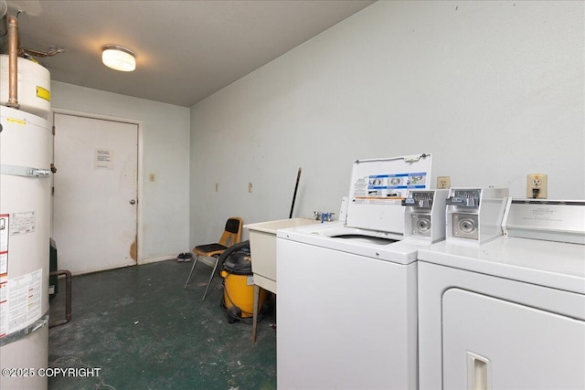 laundry room featuring washing machine and clothes dryer, water heater, and sink